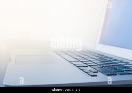 Superficie di un computer portatile contro la luce brillante. Concetto di ambiente di lavoro ben illuminato e luminoso, utilizzando il computer alla luce del giorno Foto Stock