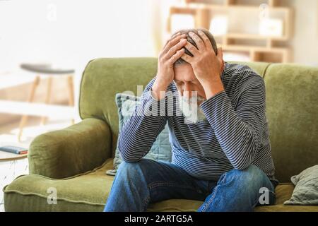 Senior l uomo che soffre di mal di testa a casa Foto Stock