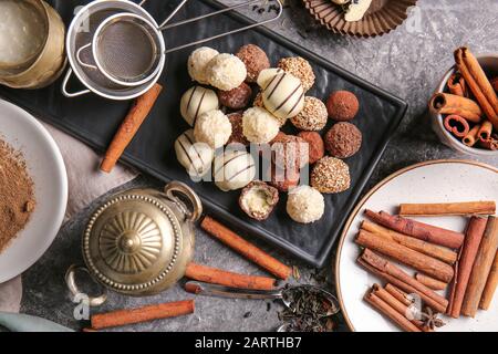 Piatto con gustosi tartufi dolci e cannella su tavola Foto Stock