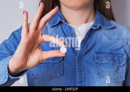 Donna che tiene in mano una pillola medica Foto Stock