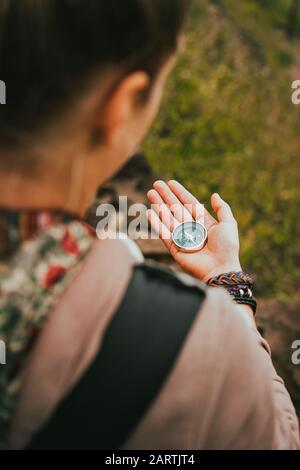 Le donne controllano la direzione alla bussola nella sua mano per trovare il giusto percorso escursionistico. Foto Stock