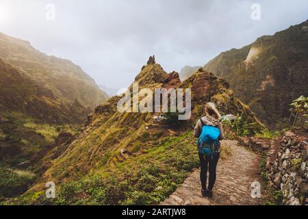 Isola Di Santo Antao Capo Verde. Ragazza turistica con zaino che cammina lungo il percorso di trekking verso la verdeggiante valle Xo-Xo tra le cime di montagna. Foto Stock