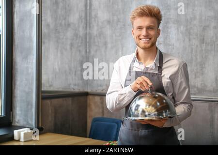 Cameriere con vassoio e cloche nel ristorante Foto Stock