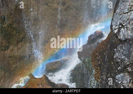 Arcobaleno che si forma in fondo alla cascata di Dalfazer (Dalfazer Wasserfall), vicino al lago Achen, Austria. Foto Stock