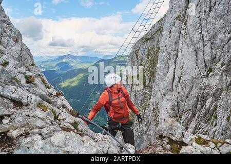 Uomo che sale via ferrata Intersport vicino a Gosau, poco prima della famosa scala diagonale. Foto Stock