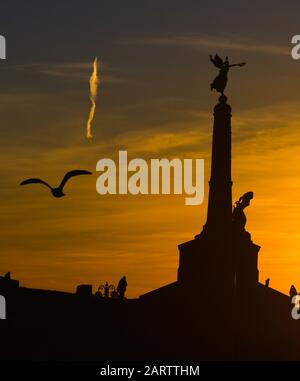 Mario Rutelli 1923 statua memoriale di guerra in silhouette contro uno sfondo arancione cielo Foto Stock