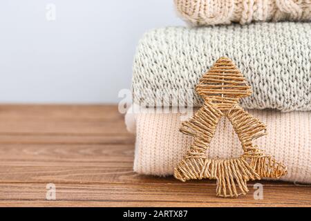 Stack di vestiti invernali con decorazioni natalizie su tavolo in legno Foto Stock