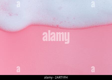 Schiuma bianca su sfondo rosa Foto Stock