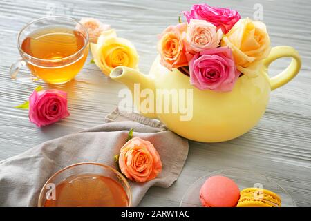 Bella rosa fiori con tè su tavolo grigio Foto Stock