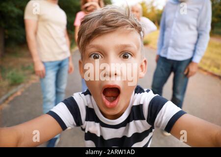 Ragazzino con la sua famiglia che scatta foto all'aperto Foto Stock