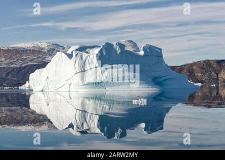 Grande iceberg riflesso in acqua limpida, fiordo, Scoresby Sund. Kangertitivaq, Groenlandia, Danimarca Foto Stock