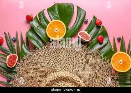 Composizione estiva con frutta tropicale, foglie e cappello su sfondo colorato Foto Stock