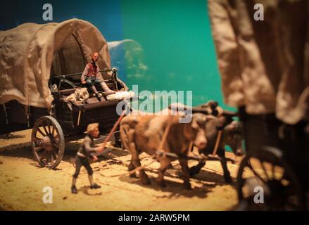 Convoglio in miniatura con carretti a cavallo e figure di persone. I primi europei scoprono l'America. Rumori e granaglie grandi - stilizzazione sotto il film. Così Foto Stock