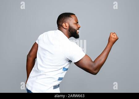 Uomo afroamericano arrabbiato su sfondo grigio Foto Stock
