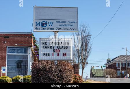 Gastonia, NC, USA-26 JAN 2020: Un negozio di armi da fuoco e di addestramento con segno che fa pubblicità a NC classe di trasporto nascosta. MGW, Mac Gun Worx vende armi da fuoco e un Foto Stock