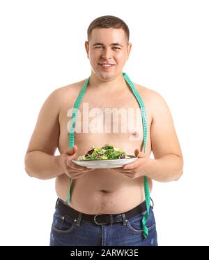 Uomo sovrappeso con metro a nastro e insalata su fondo bianco. Concetto di dieta Foto Stock