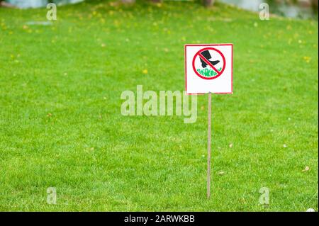Piatto con informazioni in lingua russa su non consentire di camminare su prati verdi e reparti Foto Stock