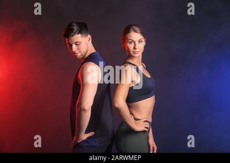 Giovane coppia sportiva su sfondo scuro Foto Stock