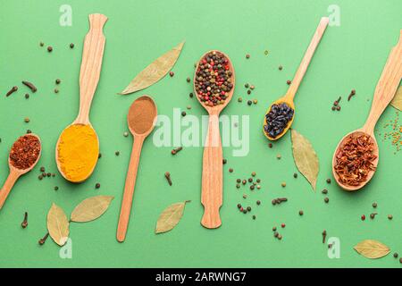 Cucchiai con diverse spezie su uno sfondo colorato Foto Stock