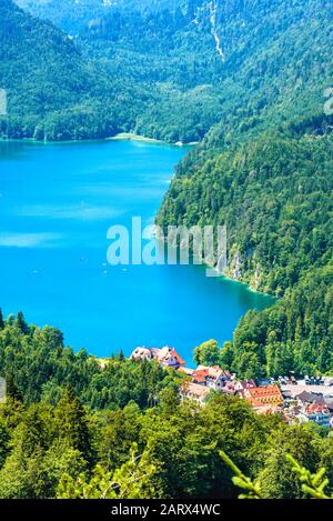 Paesaggio delle montagne alpine, Germania. Scenario delle Alpi Bavaresi in estate. Bel paesaggio con il lago Alpsee e Hohenschwangau villaggio in verde foresta Foto Stock