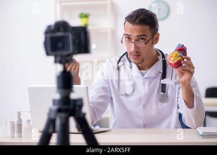 Il giovane maschio medico cardiologo di registrazione di video per il suo blog Foto Stock