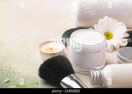 Crema cosmetica con spazzola su sfondo chiaro Foto Stock