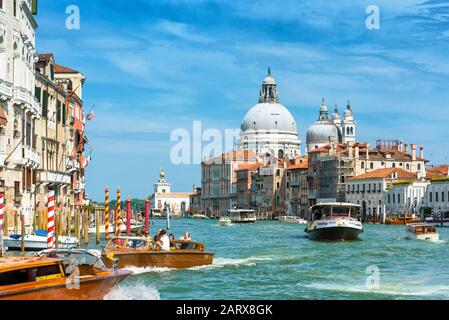 Venezia, Italia - 19 maggio 2017: I taxi d'acqua con i turisti navigano lungo il Canal Grande. Le barche a motore sono il principale mezzo di trasporto a Venezia. Basilica Di Sant Foto Stock