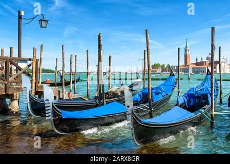 Ormeggio con gondole nei pressi di Piazza San Marco`s a Venezia, Italia. Vista sulla laguna veneta. La gondola è un tradizionale mezzo di trasporto romantico a Venezia. Foto Stock