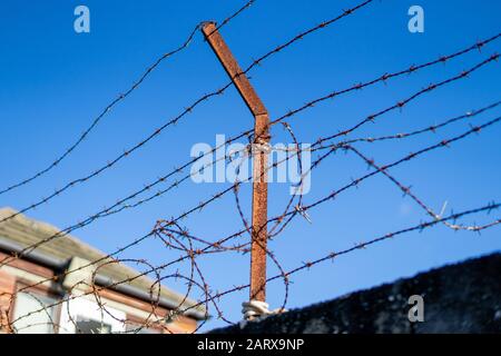 un vecchio recinto arrugginito di filo spinato Foto Stock