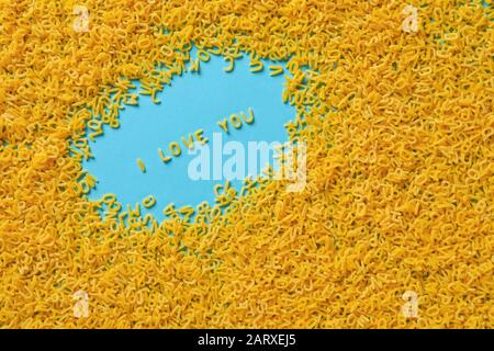 Frase TI AMO fatto di pasta secca su sfondo colorato Foto Stock
