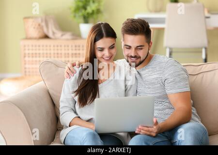 Ritratto di bella giovane coppia con il portatile a casa Foto Stock