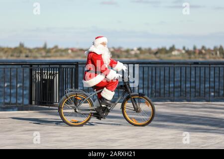 Santa Claus bicicletta a cavallo all'aperto Foto Stock