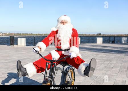 Santa Claus bicicletta a cavallo all'aperto Foto Stock