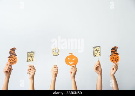 Molte mani con decorazioni di Halloween su sfondo chiaro Foto Stock