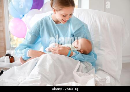 Madre giovane con neonato in ospedale di maternità Foto Stock