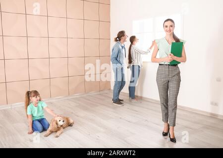 Agente immobiliare femminile con clienti interni Foto Stock