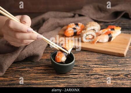 Donna che immerge il sushi gustoso in salsa di soia Foto Stock