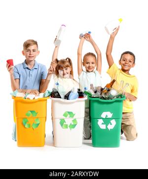 Bambini piccoli e contenitori con cestino su sfondo bianco. Concetto di riciclaggio Foto Stock