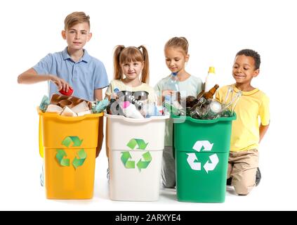 Bambini piccoli e contenitori con cestino su sfondo bianco. Concetto di riciclaggio Foto Stock