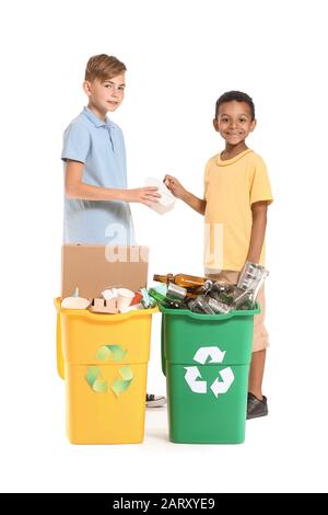 Piccoli ragazzi e contenitori con spazzatura su sfondo bianco. Concetto di riciclaggio Foto Stock