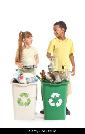 Bambini piccoli e contenitori con cestino su sfondo bianco. Concetto di riciclaggio Foto Stock