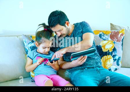 Padre e sua figlia che giocano a videogame in notebook Foto Stock