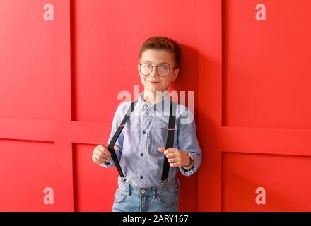 Carino ragazzo alla moda sul colore di sfondo Foto Stock