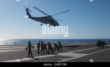 200127-N-TL141-1063 OCEANO PACIFICO (GEN. 27, 2020) I Marinai si sostengono dopo un MH-60R Sea Hawk, assegnato al "Wolfpack" di Helicopter Maritime Strike Squadron (HSM) 75, decollare dal ponte di volo della portaerei USS Theodore Roosevelt (CVN 71) 27 gennaio 2020. Il Theodore Roosevelt Carrier Strike Group è in fase di implementazione pianificata per l'Indo-Pacific. (STATI UNITI Foto Della Marina Dello Specialista Di Comunicazione Di Massa Seaman Dylan Lavin) Foto Stock