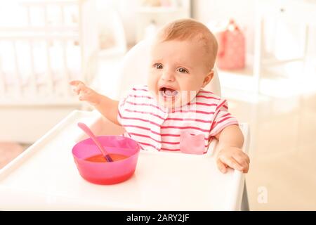 Ritratto di cute piccolo bambino mangiare cibo gustoso in cucina Foto Stock