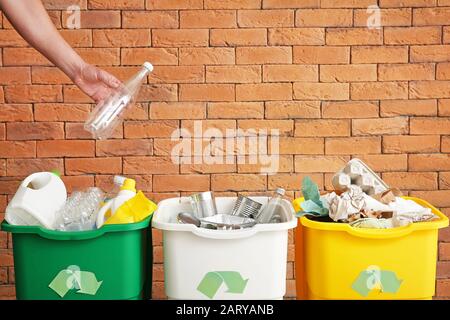 Uomo che getta rifiuti nel contenitore. Concetto di riciclaggio Foto Stock