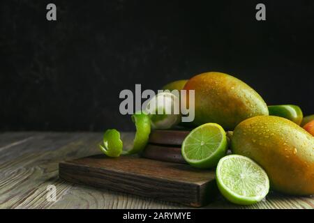 Dolci manvhi maturi e lime a tavola Foto Stock