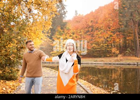 Amorevole giovane coppia a piedi nel parco autunnale Foto Stock