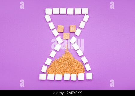 Clessidra di zucchero su sfondo colorato Foto Stock