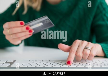 Donna con carta di credito e digitazione sulla tastiera Foto Stock